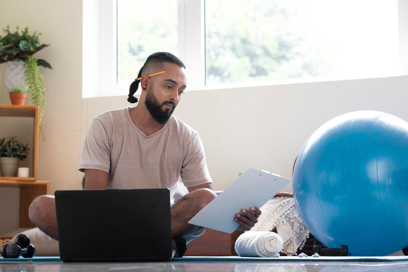 Man seated beside an exercise ball Online Physiotherapy in Chennai